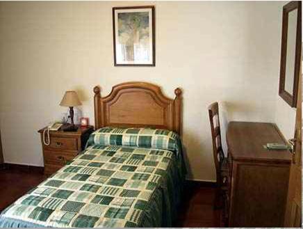 1 dormitorio con cama, tocador y mesa en Hostal Jalisco, en Ajofrín