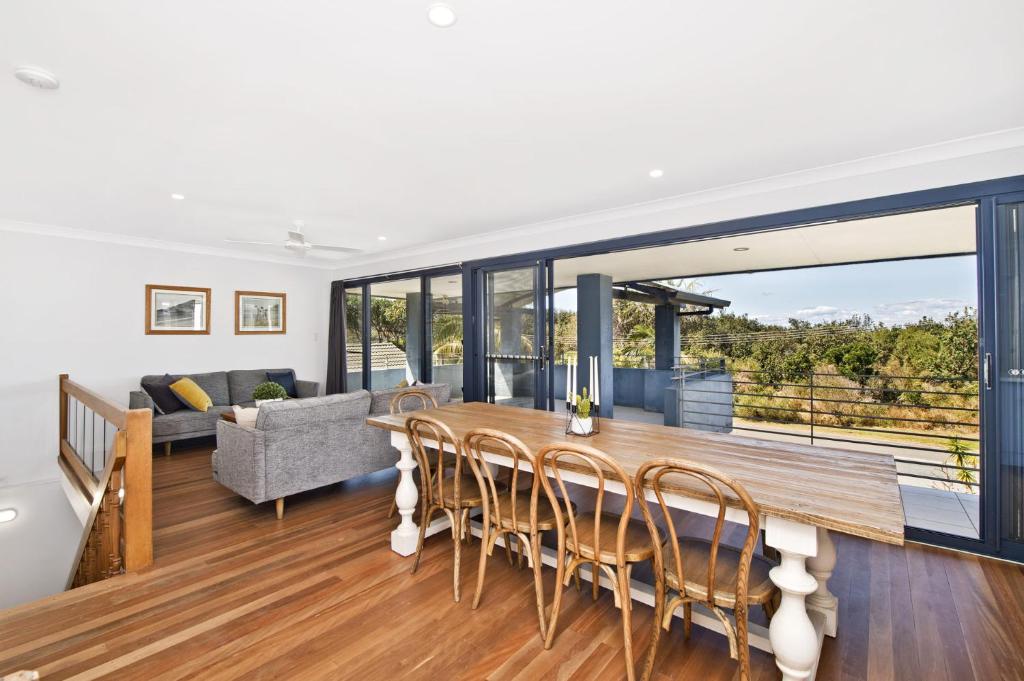 a dining room and living room with a table and chairs at 143 Matthew Flinders Drive, Port Macquarie in Port Macquarie