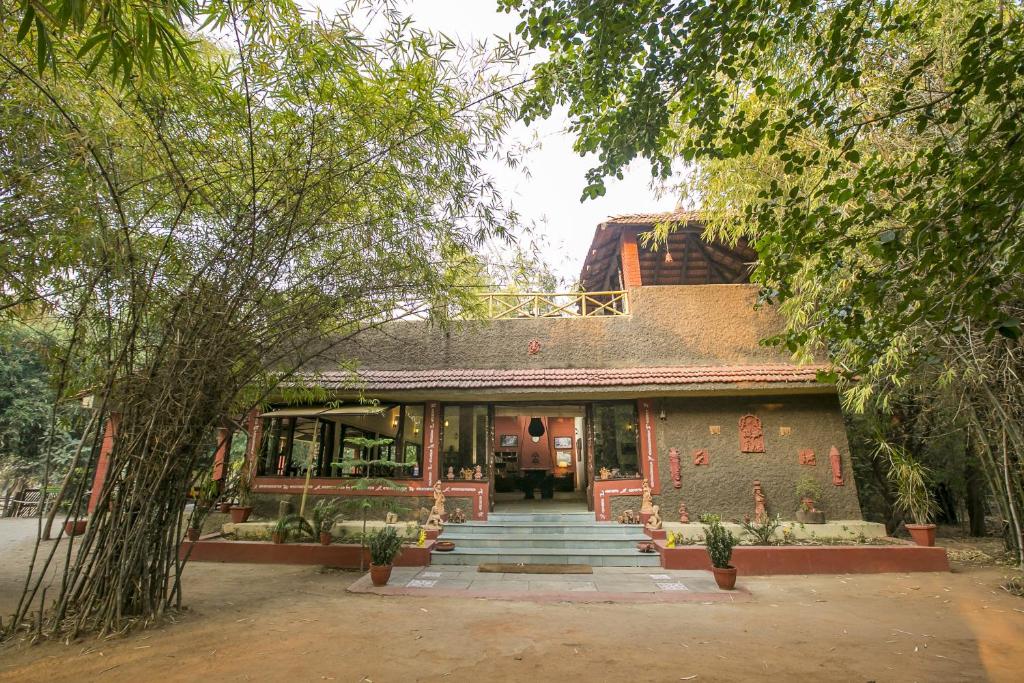 un edificio con escaleras que conducen a él con árboles en Bandhavgarh Jungle Lodge, en Tāla