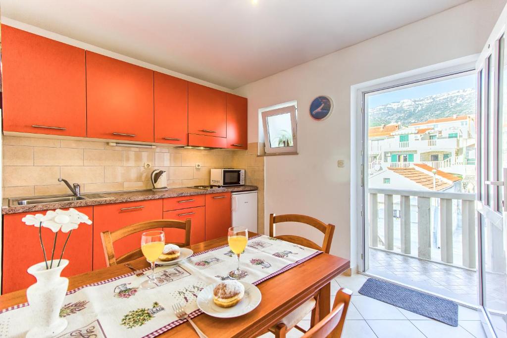 a kitchen and dining room with a table and chairs at Apartments Katarina in Bol