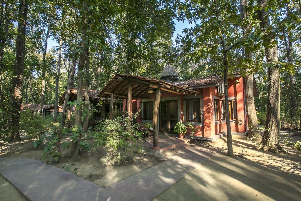 a house in the middle of a forest at Kanha Jungle Lodge in Dhanwār