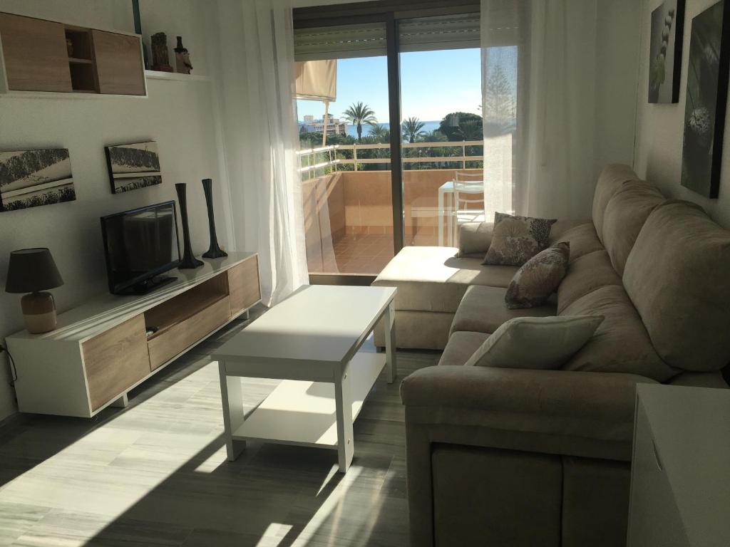 a living room with a couch and a tv at Apartamento Aguadulce Plaza Caribe in Aguadulce