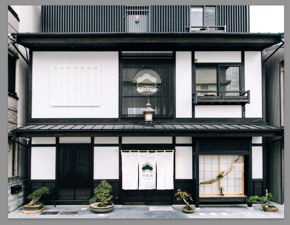 a black and white building with windows and plants at Hatagoro in Kyoto