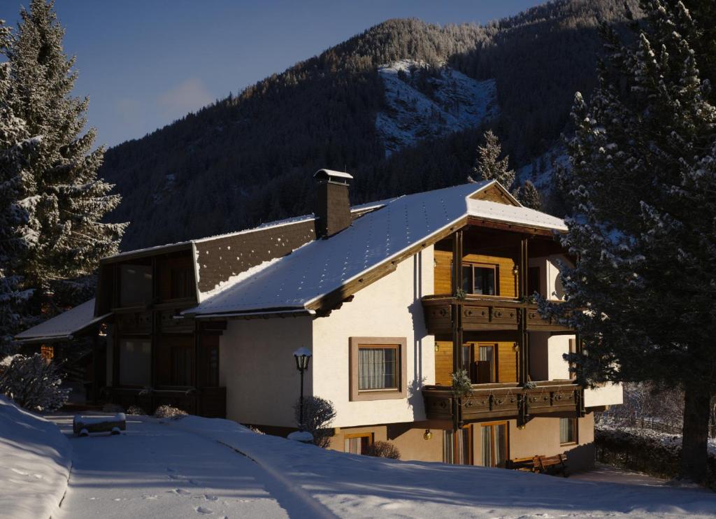 a house with a snow covered roof in the snow at Appartementhaus Habich in Bad Kleinkirchheim