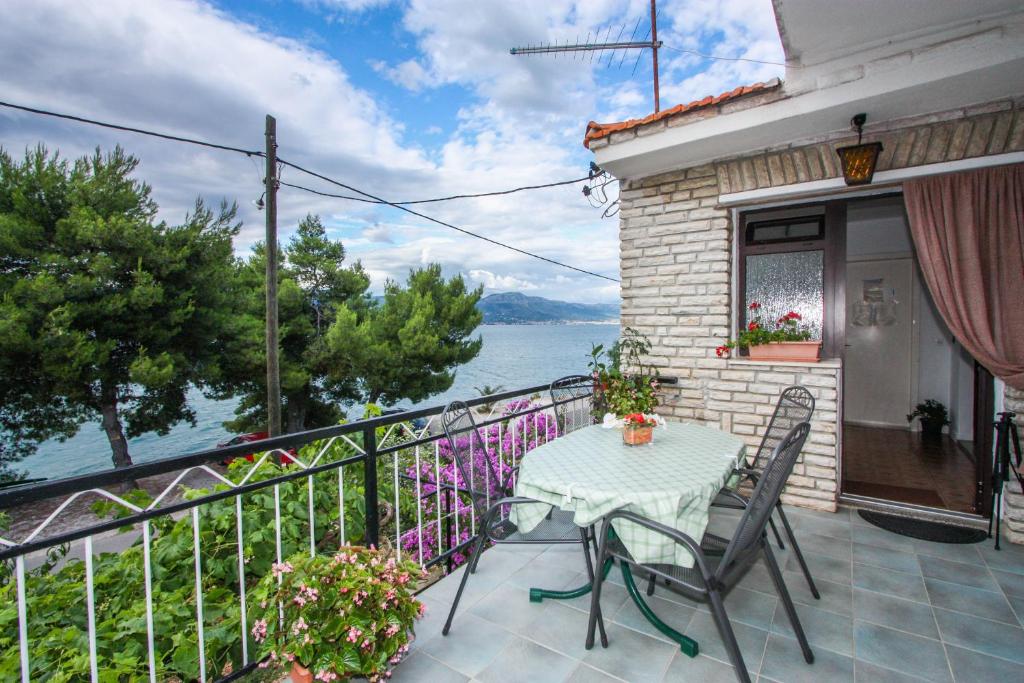 una mesa y sillas en un balcón con vistas al agua en Apartman Braco en Trogir