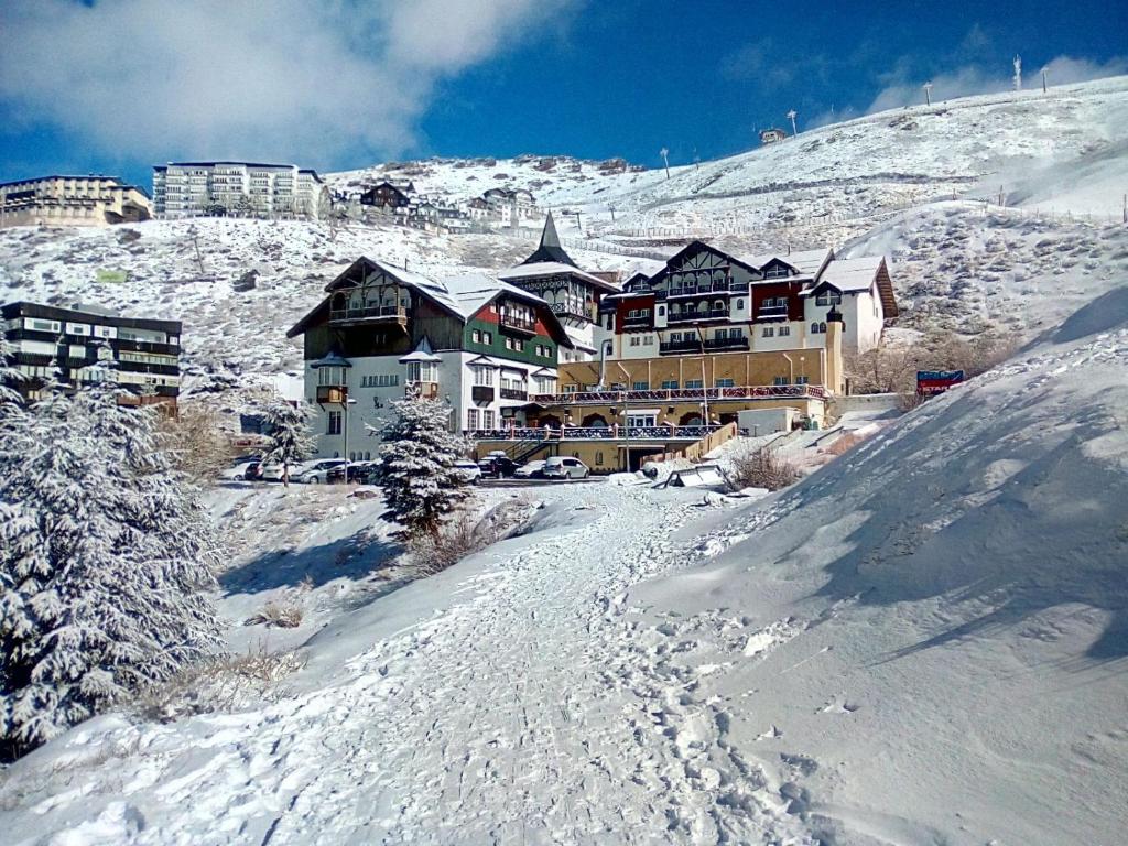 a large building on top of a snow covered mountain at Hotel GHM Monachil in Sierra Nevada