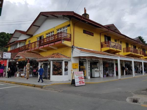 a yellow building on the side of a street at Pousada Miniférico in Campos do Jordão