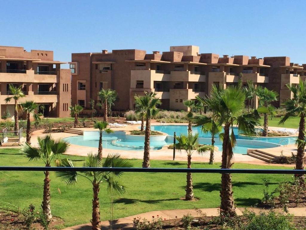een resort met palmbomen voor een gebouw bij prestigia in Marrakesh