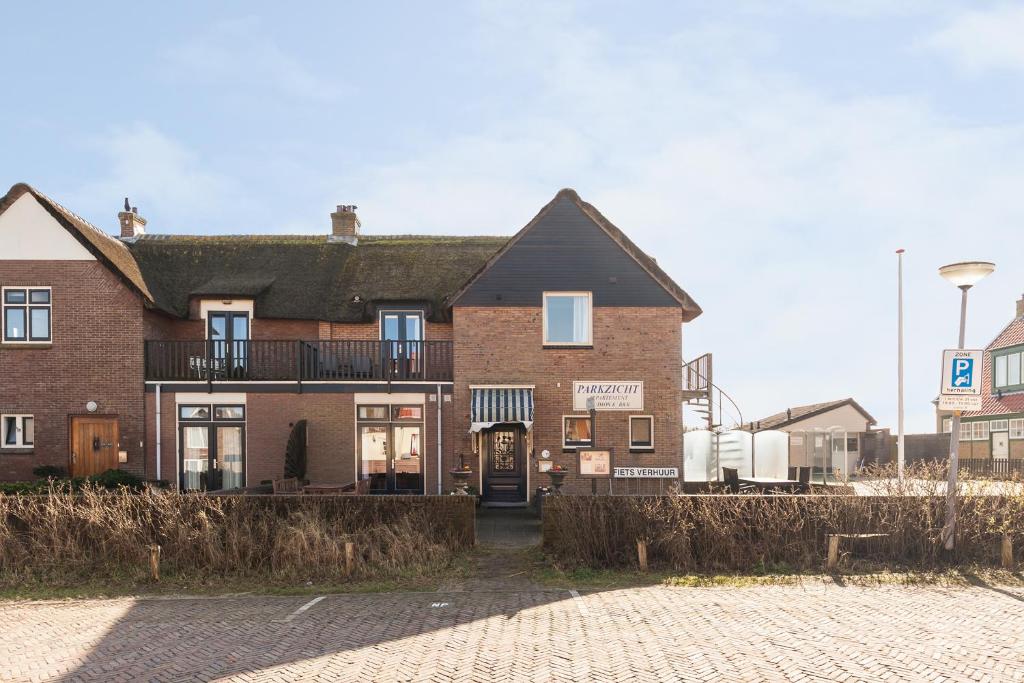 ein großes Backsteinhaus auf einer Straße in der Unterkunft Appartementen Parkzicht in Bergen aan Zee