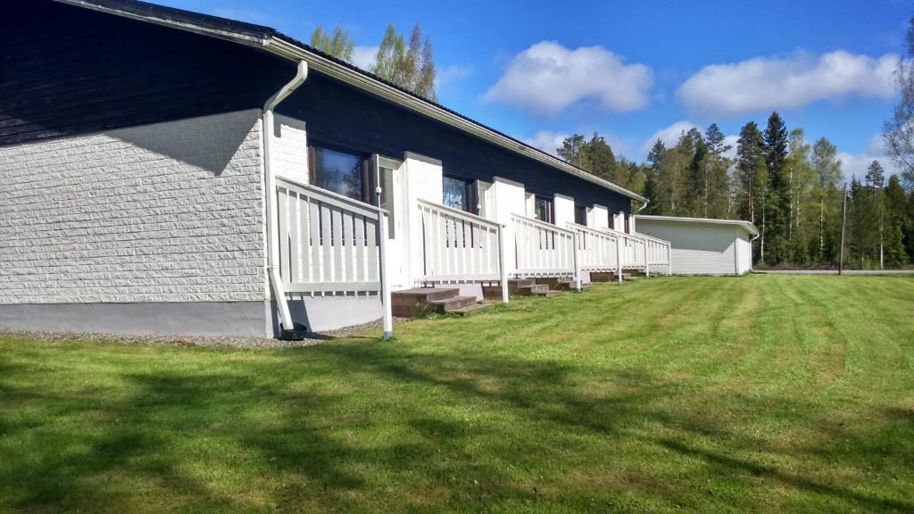a group of white buildings with a grass yard at Karijoen Helmi in Karijoki
