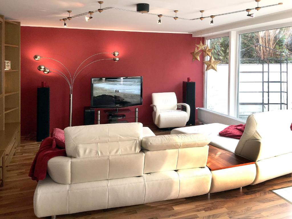 sala de estar con sofá blanco y TV en Ferienwohnung Dettum, en Dettum