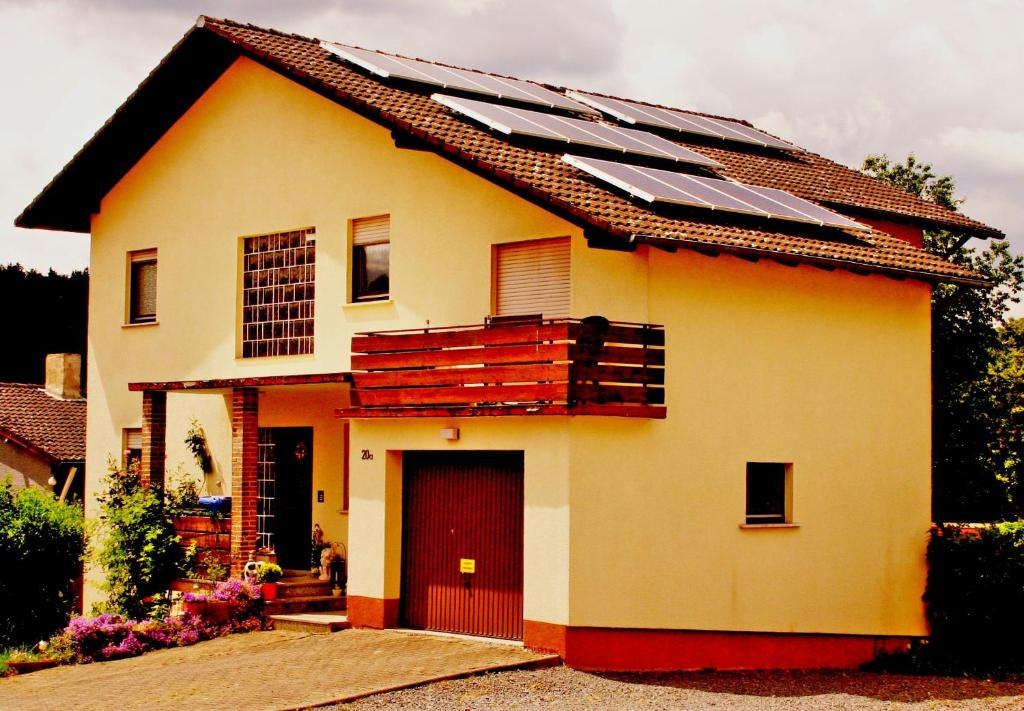 ein Haus mit Sonnenkollektoren darüber in der Unterkunft Ferienwohnung Schaefer in Michelstadt