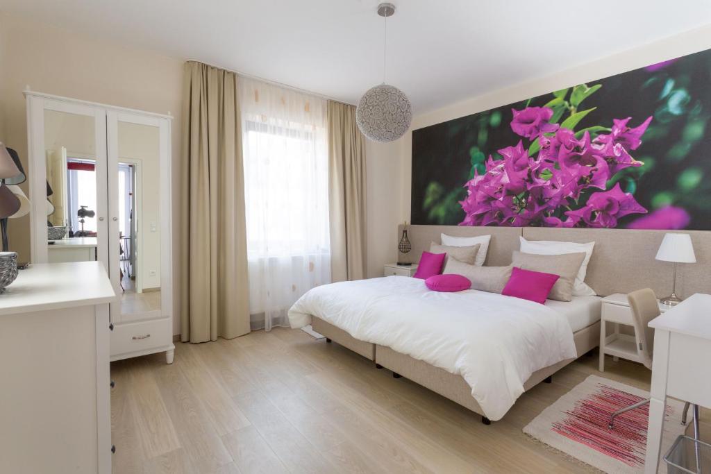 ein Schlafzimmer mit einem großen Blumengemälde an der Wand in der Unterkunft Villa Renatus in Obernburg am Main