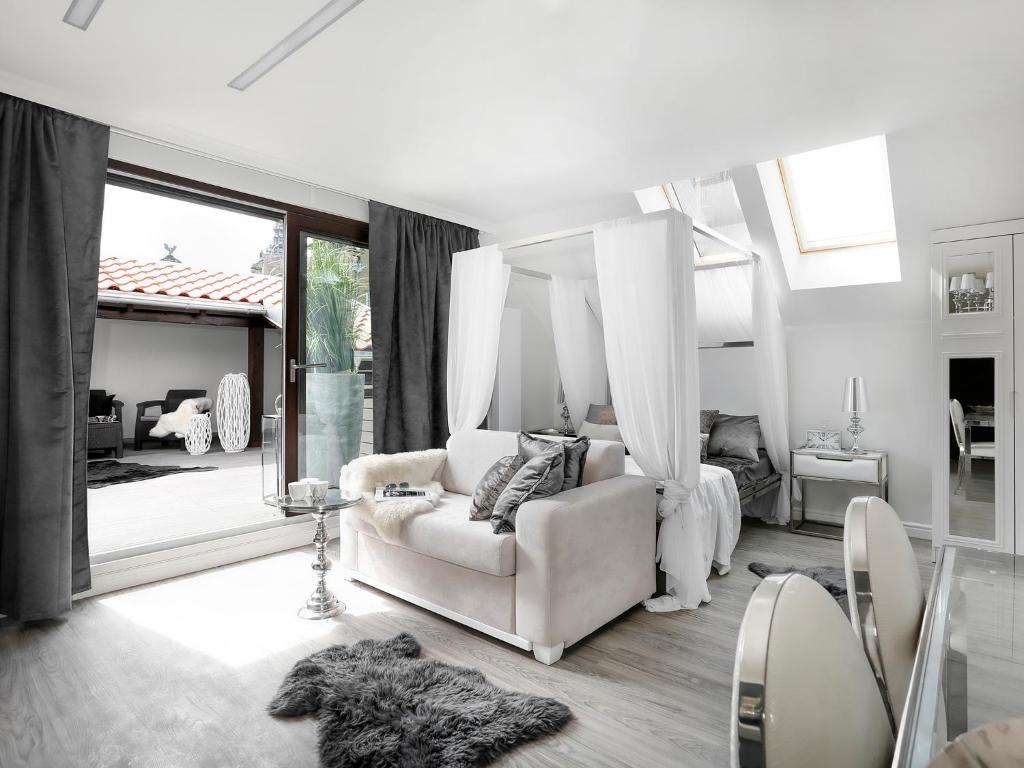 a living room with a white couch and a large window at Sweet Suite in Gdańsk