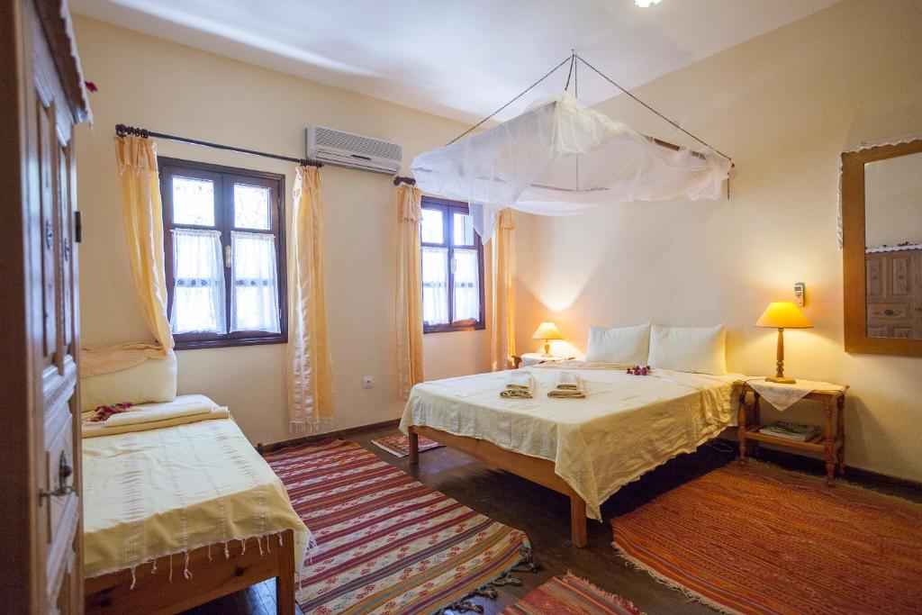 a bedroom with a bed with a canopy and two windows at Kalkan Turk Evi in Kalkan