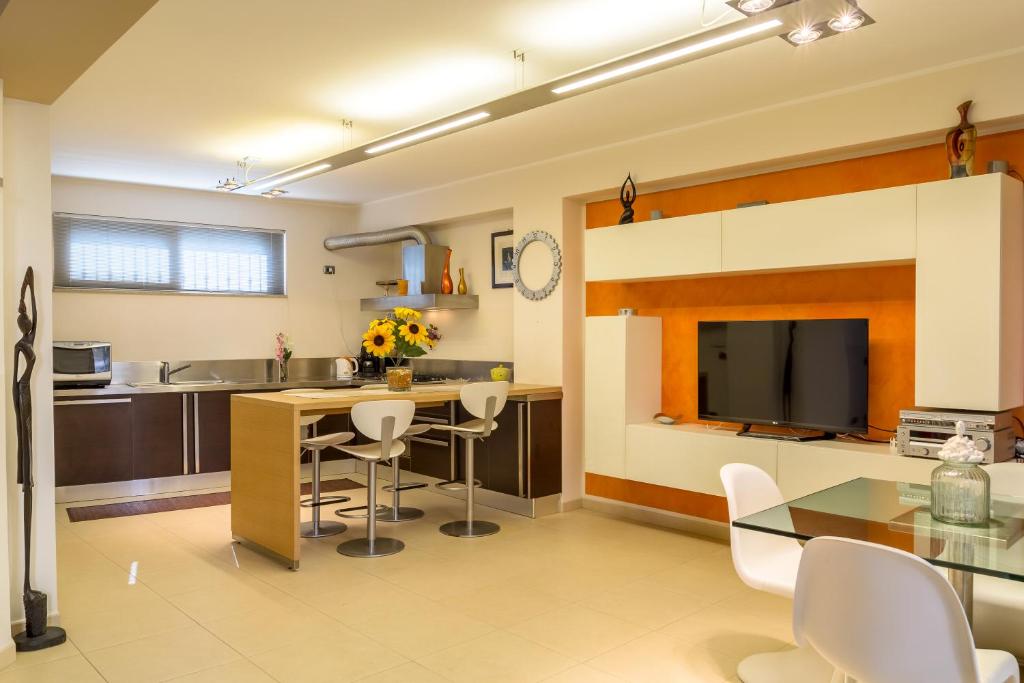a kitchen with a table and chairs and a television at Casa Lì in Giardini Naxos