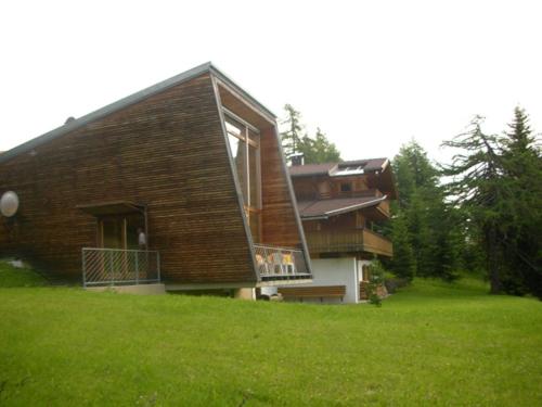 uma casa sentada em cima de um exuberante campo verde em Rifugio Bernhard em Obernussdorf