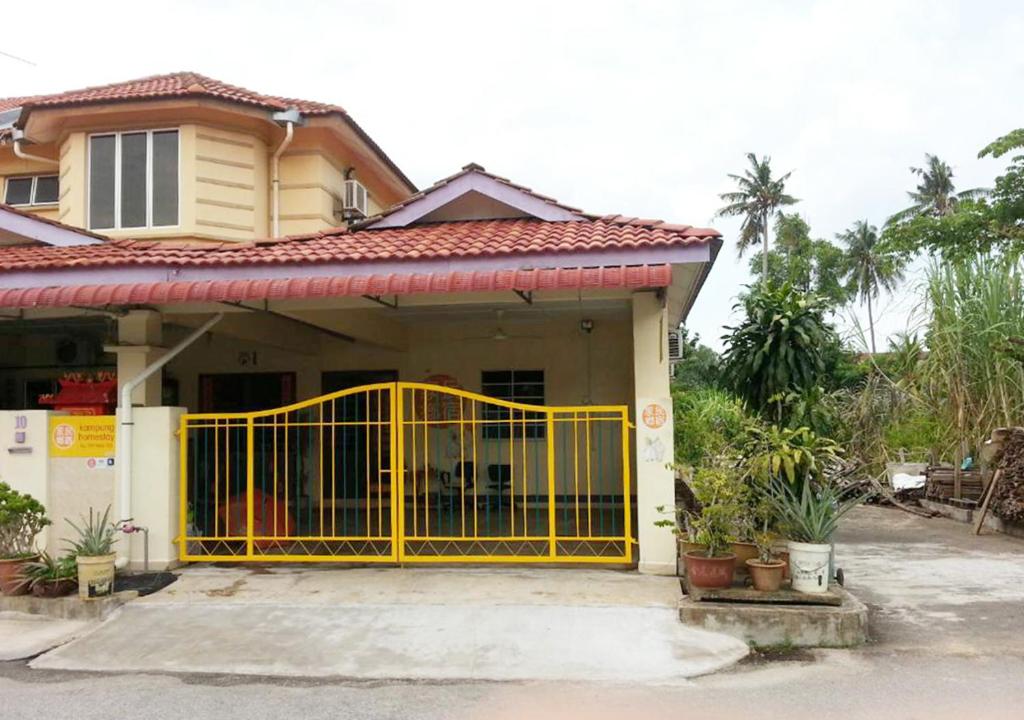 un cancello giallo davanti a una casa di Kampung Homestay, Kuantan a Kuantan