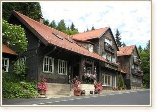 uma casa com um telhado vermelho com flores em frente em Rhönhäuschen UG (haftungsbeschränkt) em Bischofsheim an der Rhön