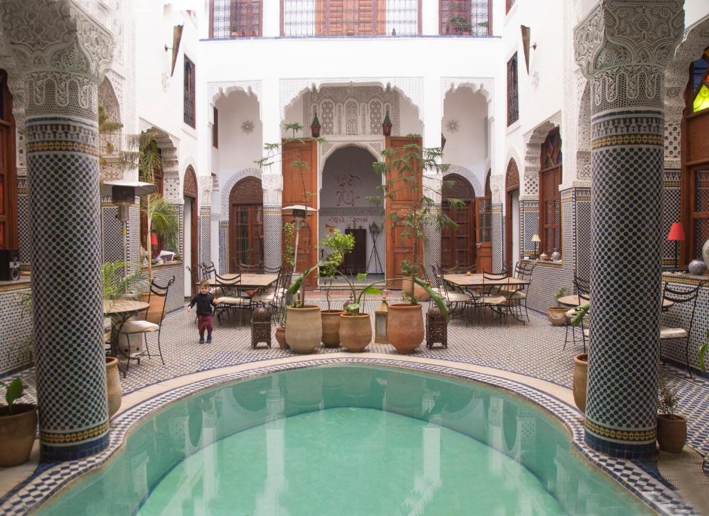 een binnenplaats met een zwembad in een gebouw bij Riad Jamaï in Fès