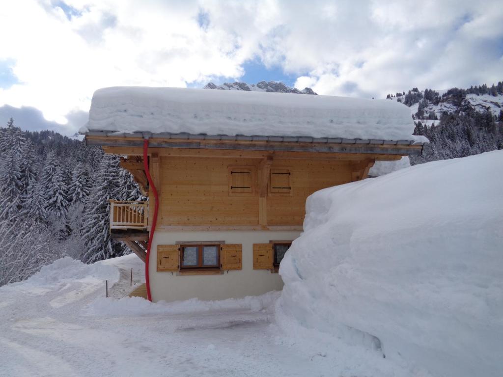 un bâtiment recouvert de neige avec un tas de neige dans l'établissement La Bartavelle, à La Giettaz