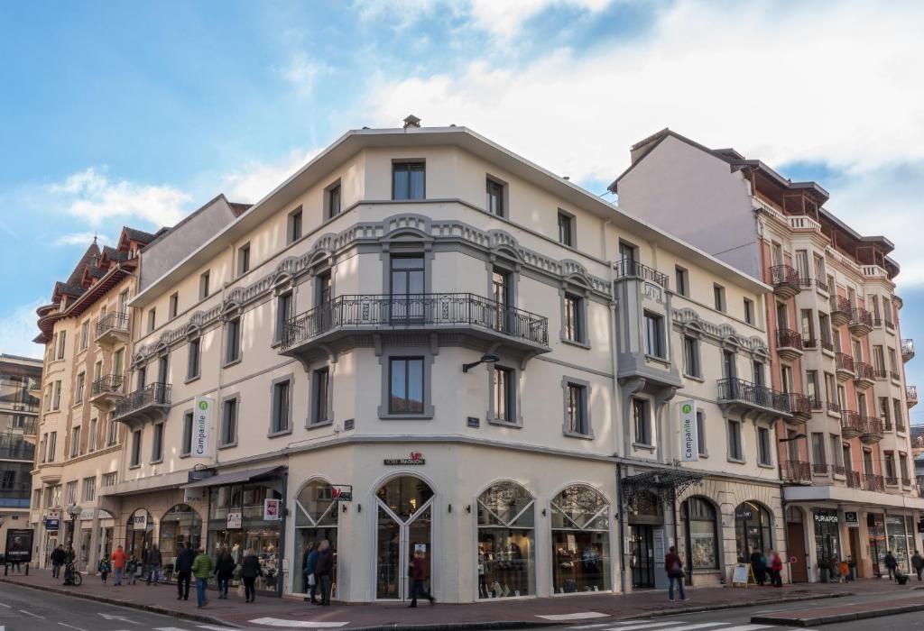 een wit gebouw op de hoek van een straat bij Campanile Annecy Centre - Gare in Annecy