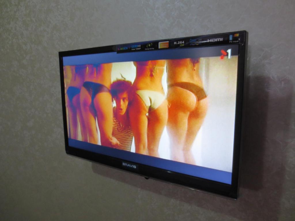 una pantalla de televisión con una foto de mujeres en ropa interior en Квартира возле Радмир ул.Чернивецкая 5в, en Járkov