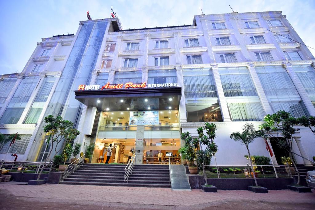 a large white building with stairs in front of it at Hotel Amit Park International in Bhilai