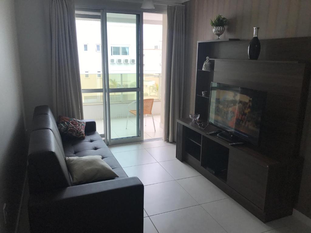 sala de estar con sofá y TV de pantalla plana en Apartamento de 3 Quartos na Praia dos Ingleses, en Florianópolis