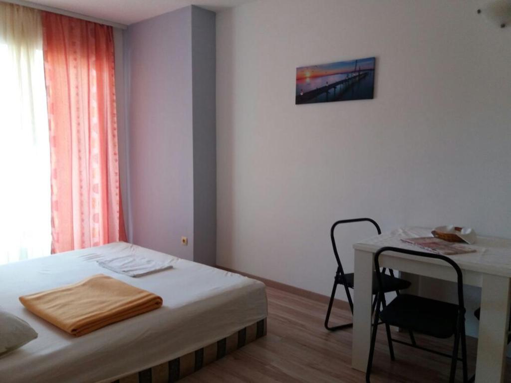 a small bedroom with a bed and a table at Apartment Perica in Omiš