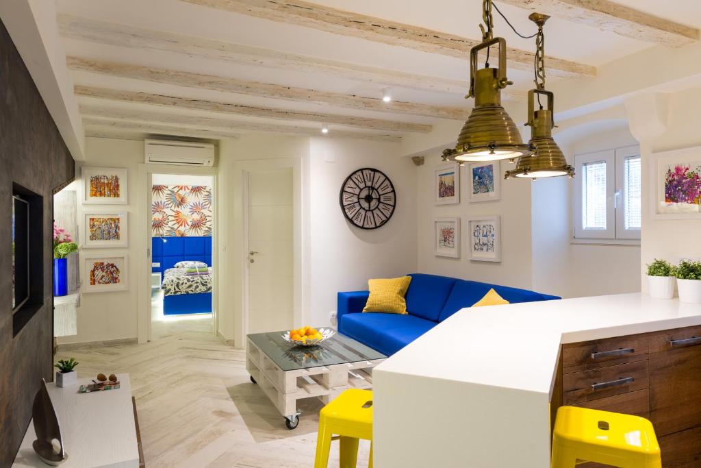 - un salon avec un canapé bleu et des fauteuils jaunes dans l'établissement Laguna Superior Apartment, à Dubrovnik