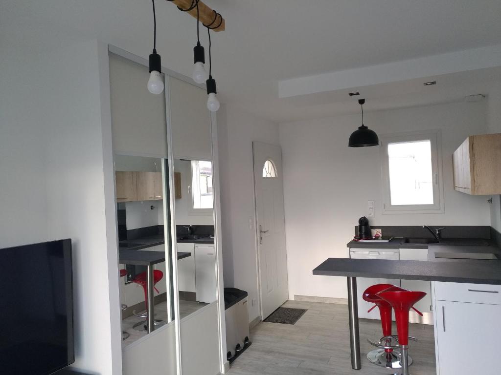 a kitchen with a table and a red stool at Plaisance du Touch in Plaisance-du-Touch