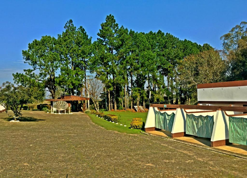 un parque con un edificio y árboles al fondo en Hotel Comodoro de Rosário Do Sul, en Rosário do Sul