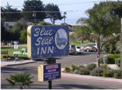 un cartello blu per una locanda di succhi di frutta in strada di Blue Seal Inn a Pismo Beach