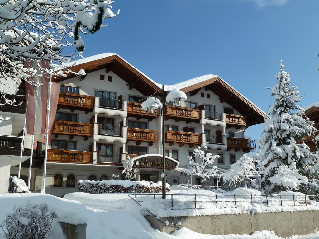 ein Hotel im Schnee mit einem Weihnachtsbaum in der Unterkunft Hotel Feldwebel in Söll