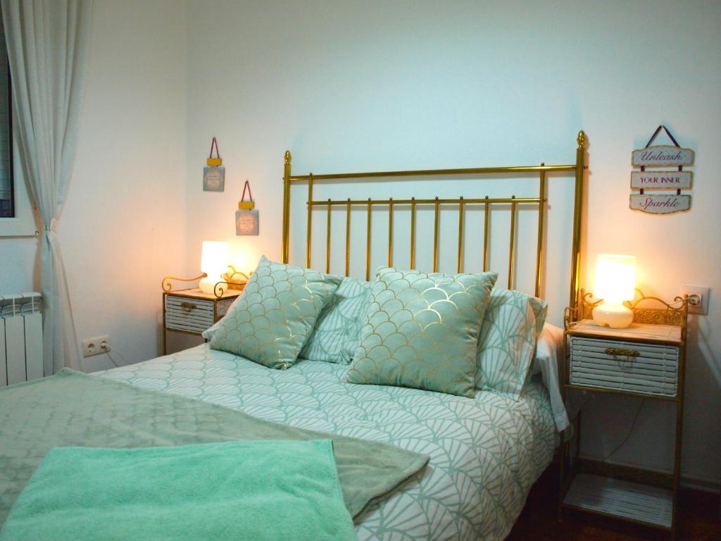 レオンにあるPiso Madrazoのベッドルーム1室(枕、ランプ2つ付)