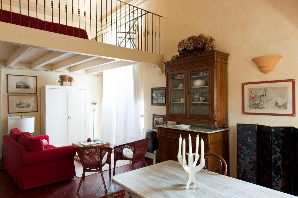 a living room with a table and a red couch at Castello di Rocca Grimalda in Rocca Grimalda