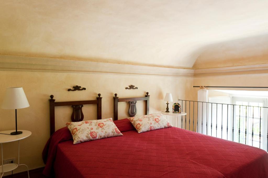 a bedroom with a red bed with two pillows at Castello di Rocca Grimalda in Rocca Grimalda