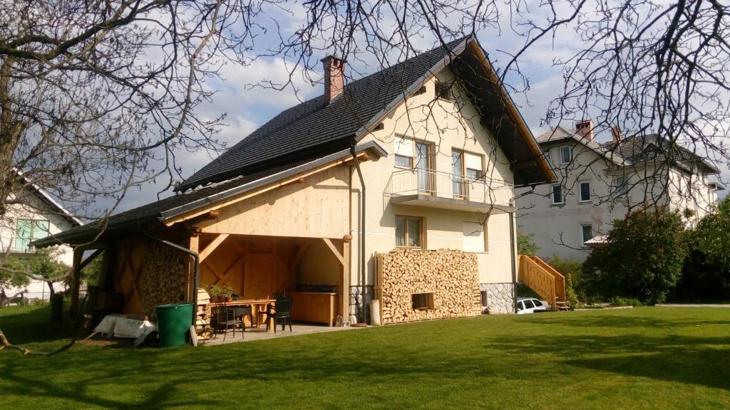 ein großes weißes Haus mit einem Gameradach in der Unterkunft Green Garden Apartment in Bled