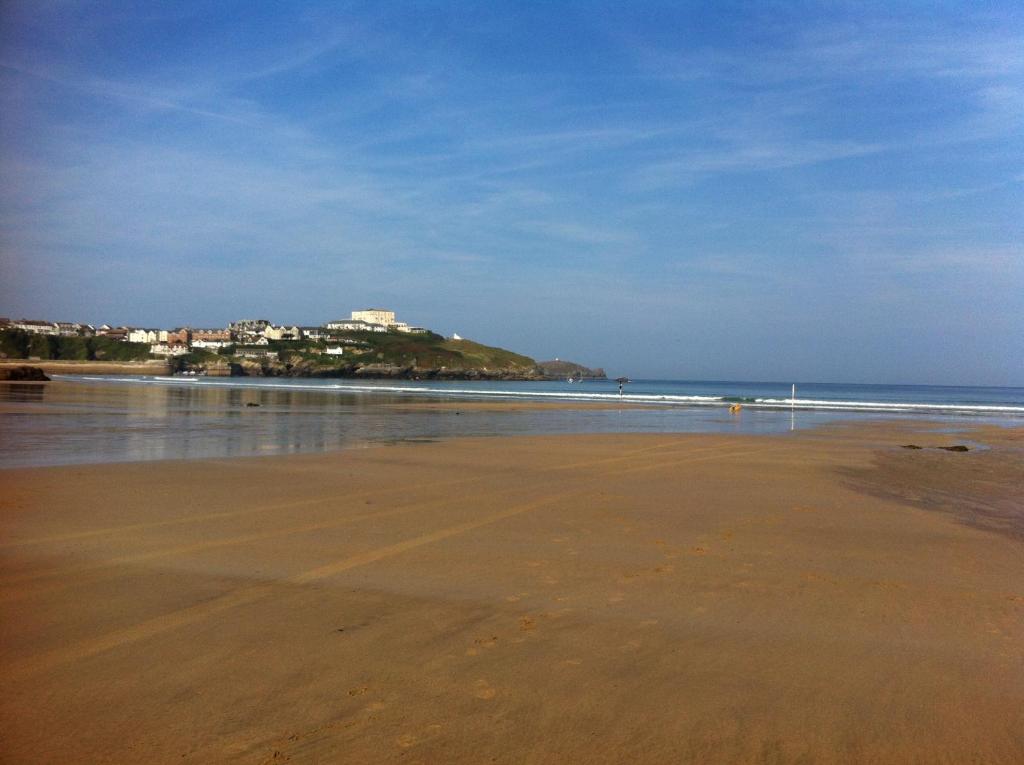 une plage avec l'océan et une ville en arrière-plan dans l'établissement Alishan Cornwall Holidays sleep up to 6, à Newquay
