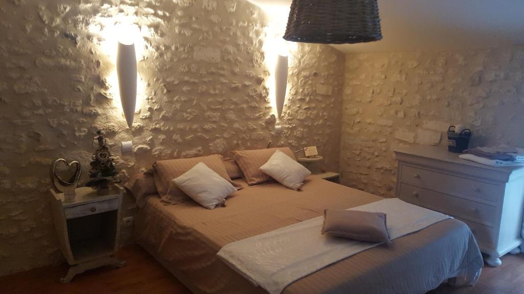 a bedroom with a bed with two pillows and a dresser at Clos des Morillons in Vénérand