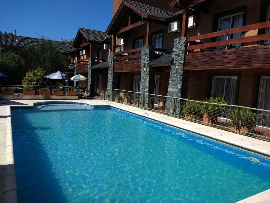 una piscina frente a un edificio en Aguas Claras Hosteria en Santa Rosa de Calamuchita