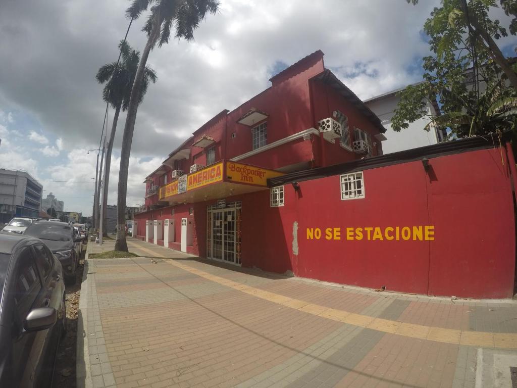 um edifício vermelho no lado de uma rua em Pensión América na Cidade do Panamá