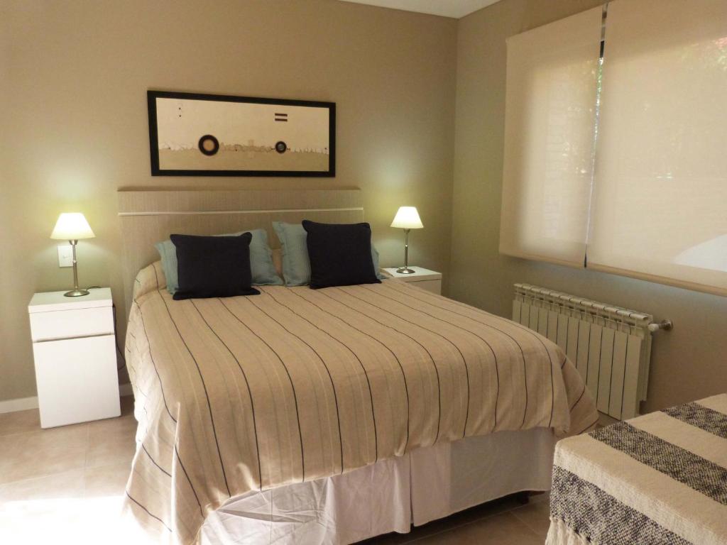 una camera con un letto con due comodini e due lampade di Departamento Drury a San Martín de los Andes
