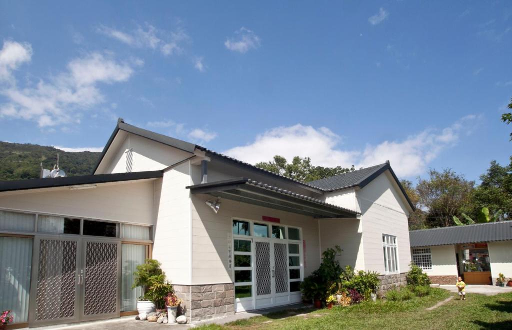 una casa blanca con techo negro en Chulu ecological farm B&B, en Chulu