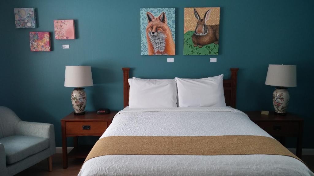 1 dormitorio con cama y pared azul en Harwood Hill Motel en Bennington