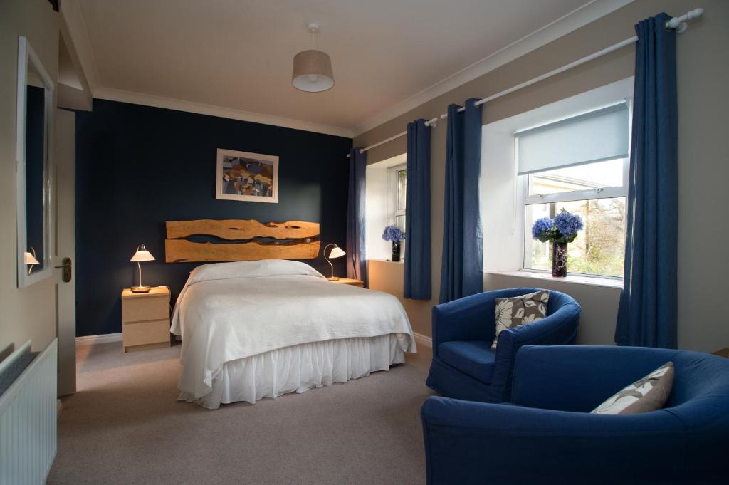 クリフデンにあるSharamore House B&Bのベッドルーム1室(ベッド1台、青い椅子付)