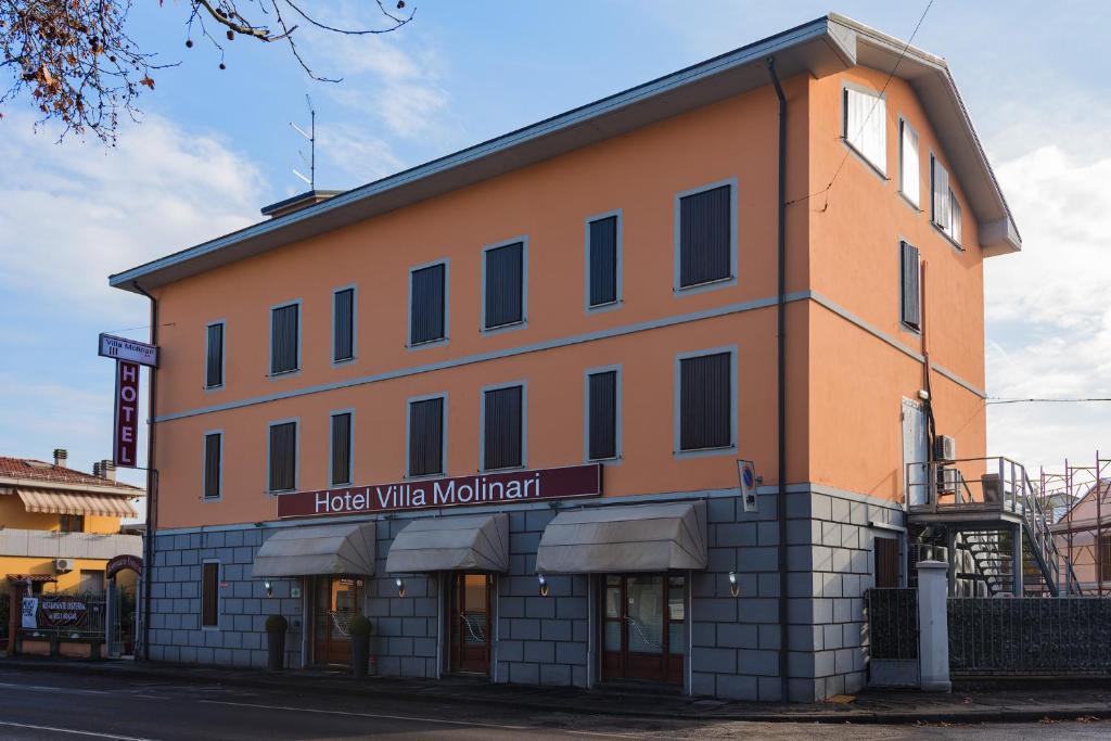 un grand bâtiment orange avec un panneau. dans l'établissement Hotel Villa Molinari, à Collecchio