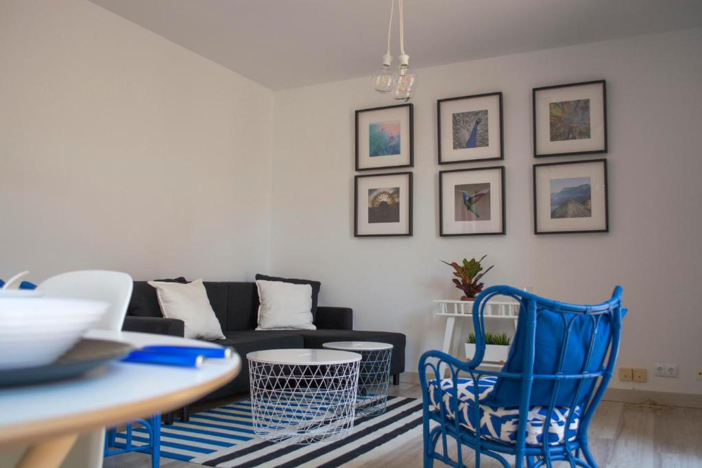 sala de estar con sillas azules y sofá en VIVIENDA DE USO TURÍSTICO CASA ABAD, en Ávila