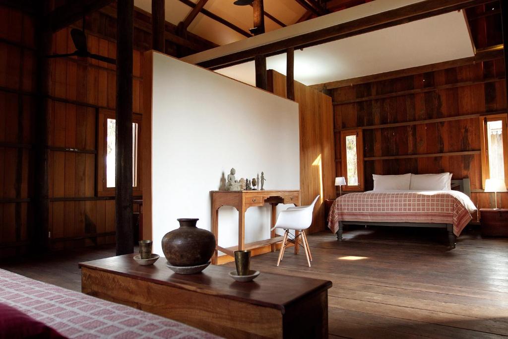 a bedroom with a bed and a table and a chair at Sala Lodges in Siem Reap